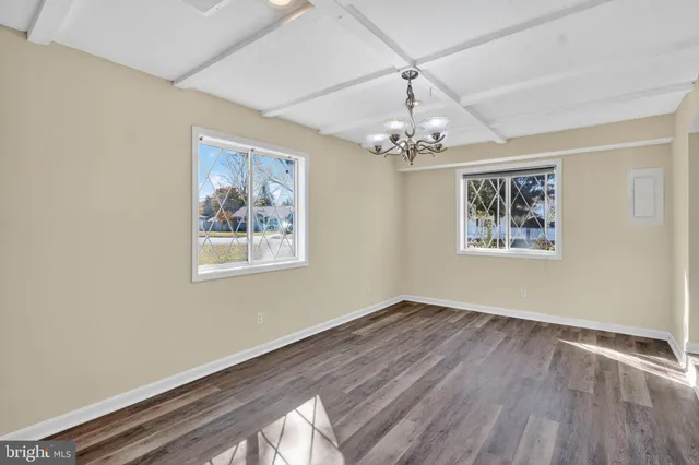 a view of a hallway with wooden floor and chandelier