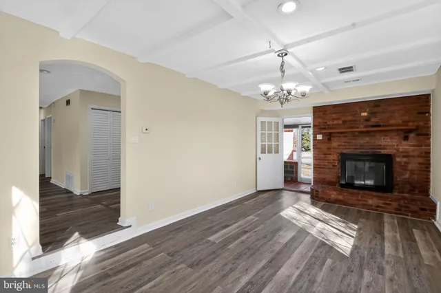 a living room with a fireplace and wooden floor