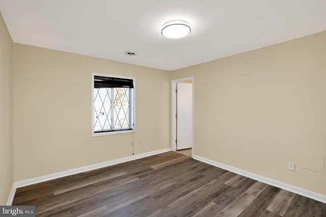 an empty room with wooden floor and a window