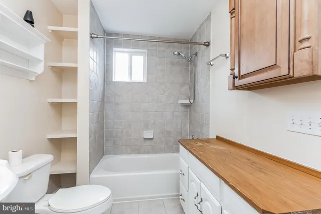 a bathroom with a granite countertop toilet sink and bathtub