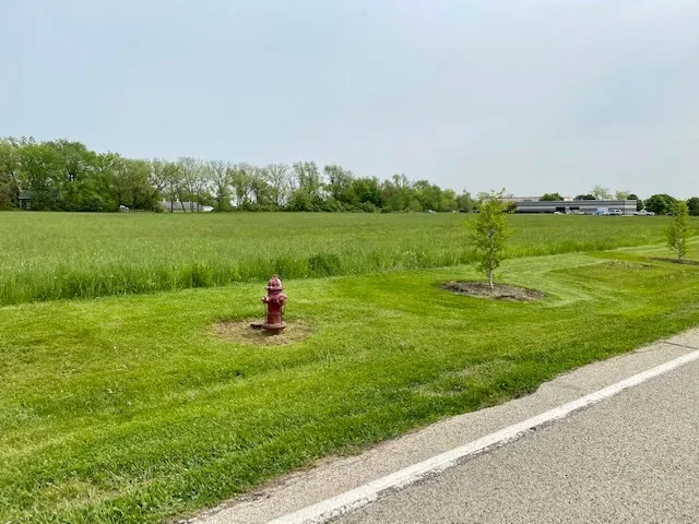 a view of a lake with a big yard and large trees