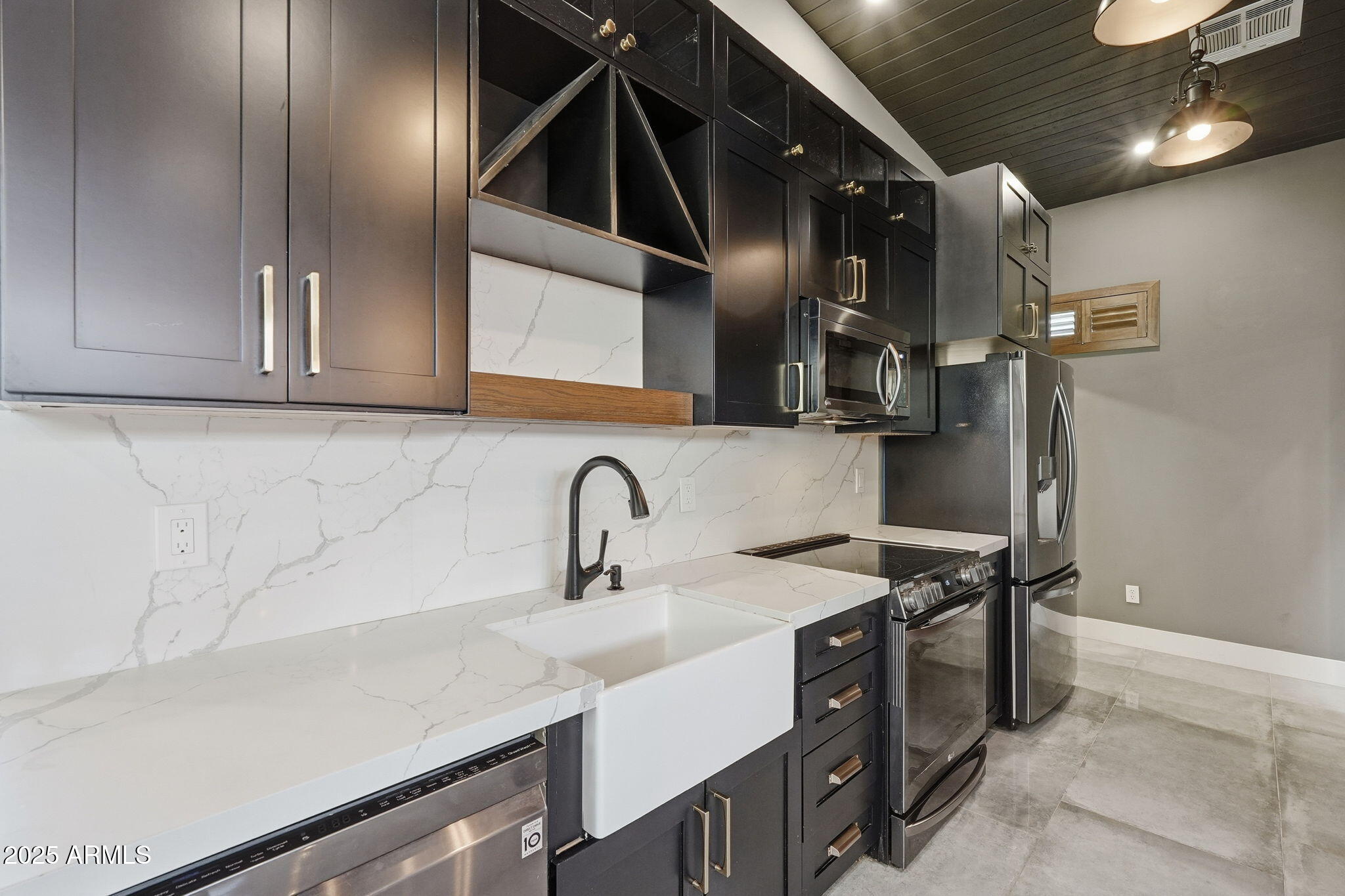 914 South 132nd Street Gilbert, AZ 85233 - Photo 42 of 55 a kitchen with stainless steel appliances a sink a stove and a refrigerator