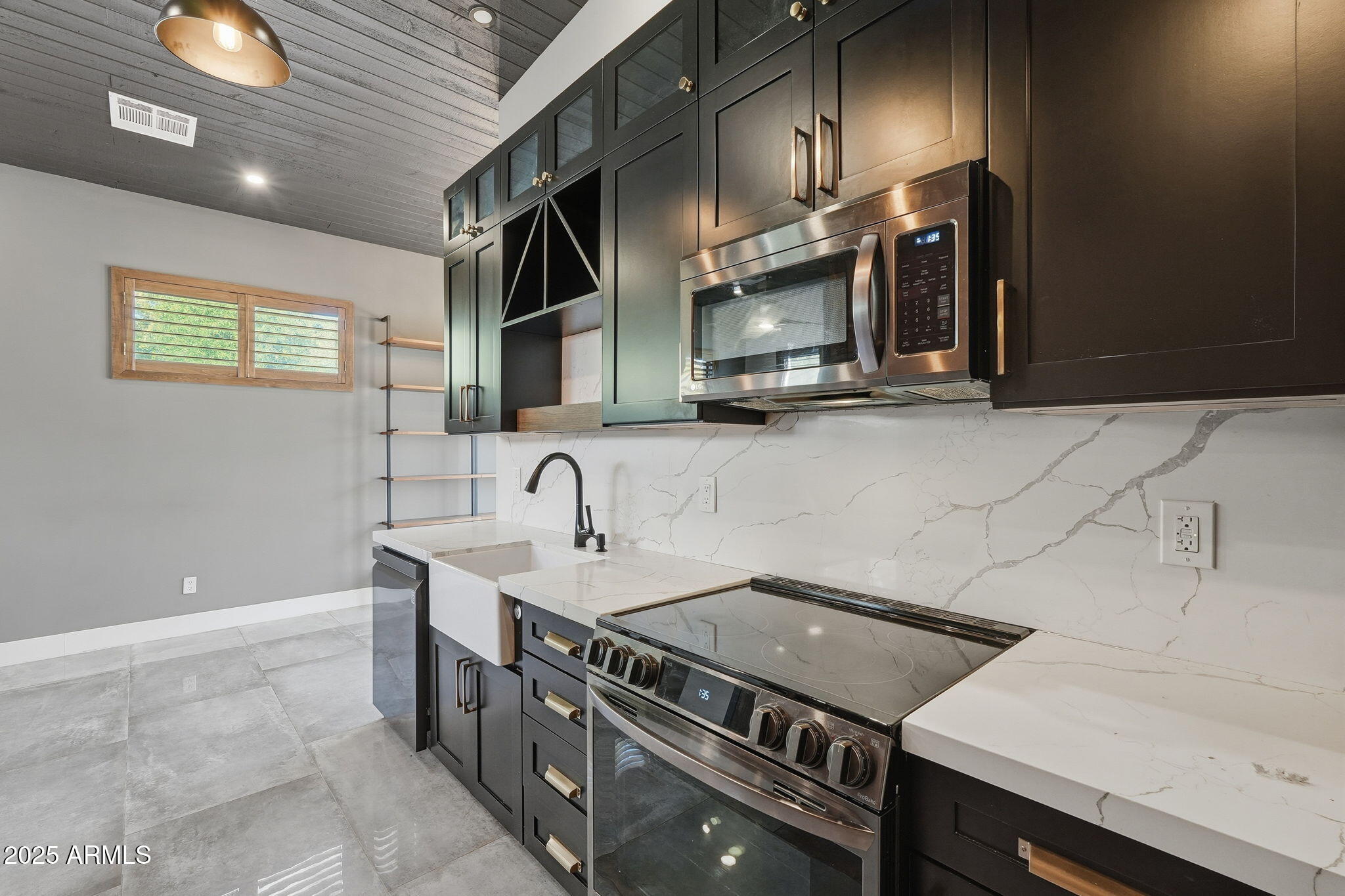 914 South 132nd Street Gilbert, AZ 85233 - Photo 43 of 55 a kitchen with stainless steel appliances a sink a stove and a microwave