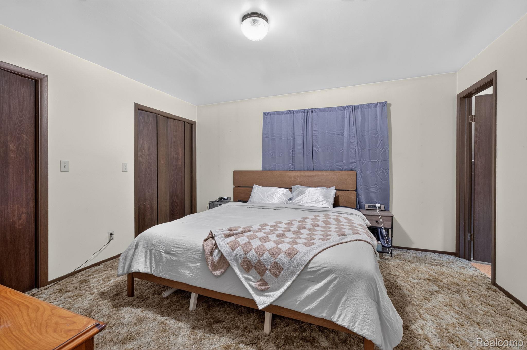 5330 Sheridan Road Saginaw, MI 48601 - Photo 36 of 50 Spacious bedroom featuring light-toned walls, wood-finish doors, and plush carpeting