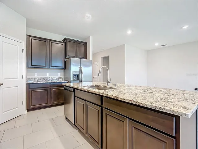 a kitchen with stainless steel appliances granite countertop a sink stove and microwave
