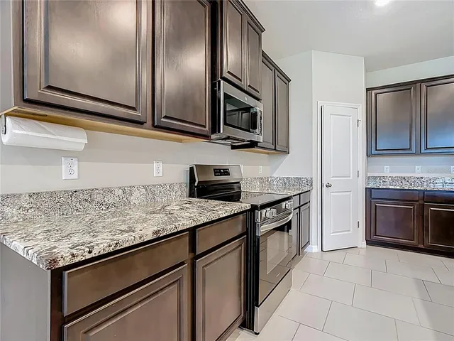 a kitchen with stainless steel appliances granite countertop a sink refrigerator and microwave