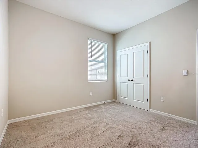 an empty room with closet and a bathroom