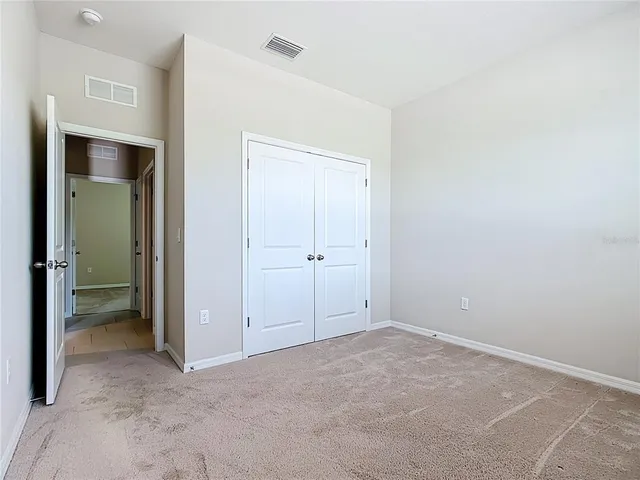 a view of a hallway with wooden floor and a living room