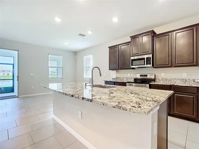 a kitchen with stainless steel appliances granite countertop a sink and a microwave