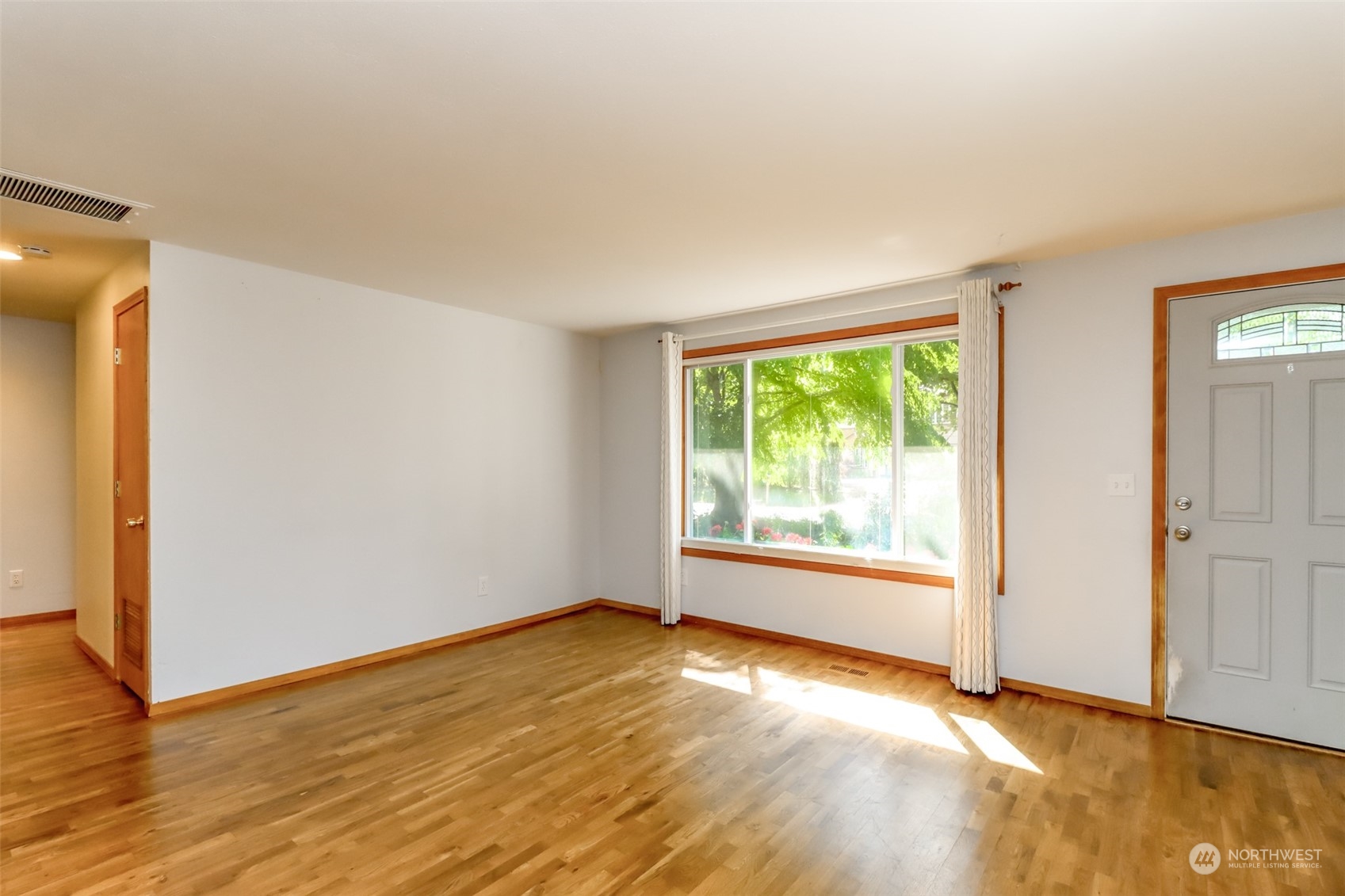 14419 178th Avenue Southeast Renton, WA 98059 - Photo 5 of 40 an empty room with wooden floor and windows