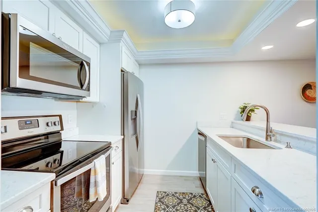 a kitchen with stainless steel appliances granite countertop a sink and a microwave