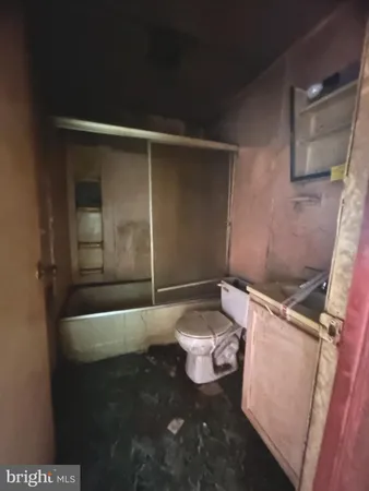 a bathroom with a toilet a sink a mirror a bathtub and vanity