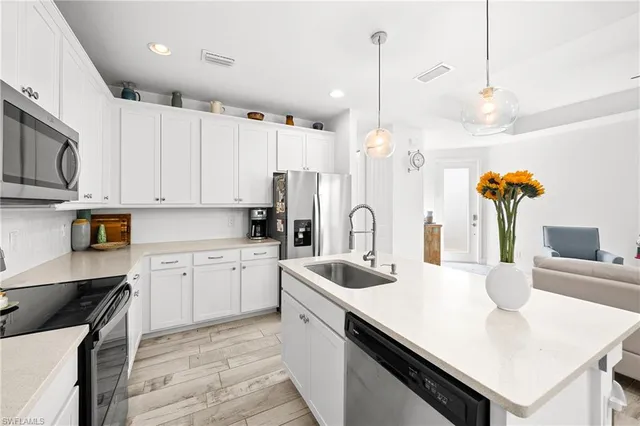 a kitchen with stainless steel appliances granite countertop a stove and a white cabinets