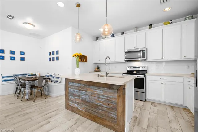 a kitchen with kitchen island a sink appliances and cabinets