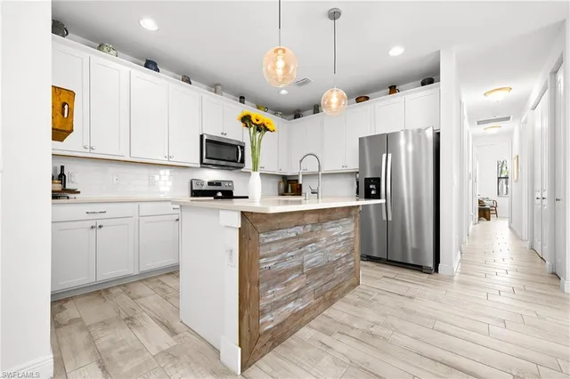 a kitchen with kitchen island granite countertop a sink cabinets and wooden floor