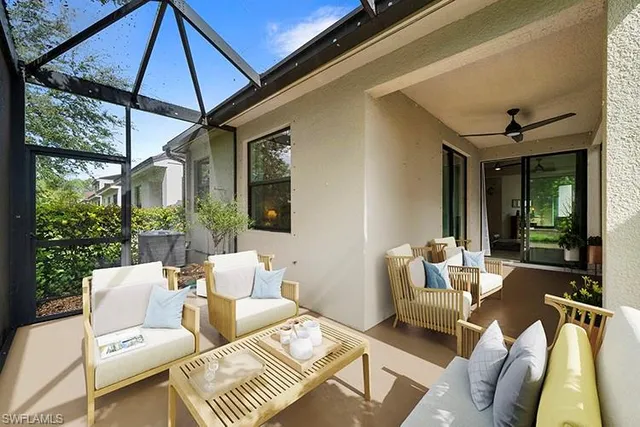 a view of a patio with couches chairs potted plants and a large tree