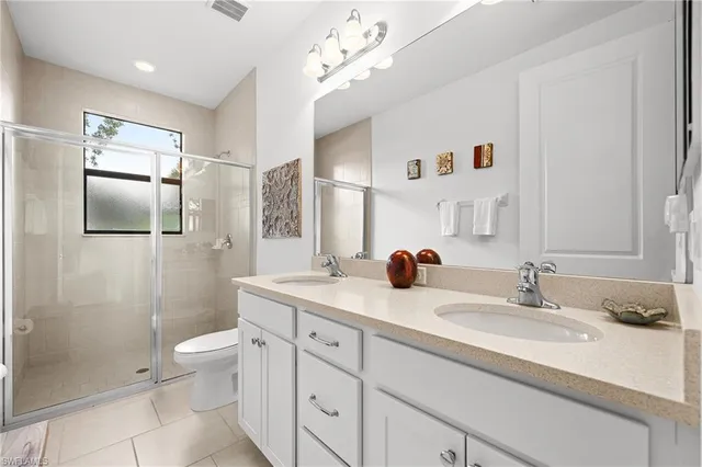 a bedroom with a bed and a lamp on dresser