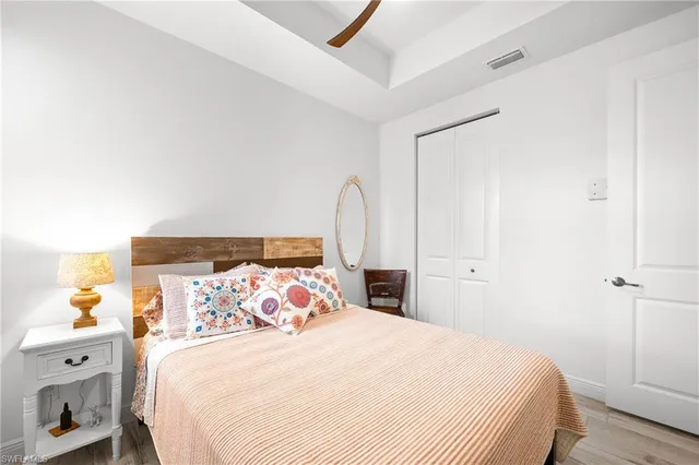 a bedroom with a bed a painting on the wall and a window