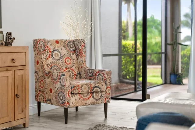 a living room with furniture large window and wooden floor