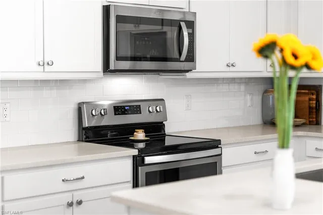 a kitchen with a sink and a stove top oven with wooden floor