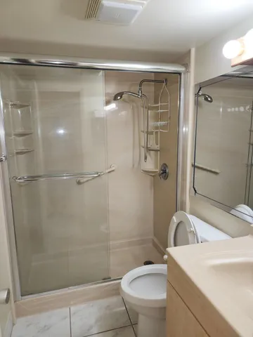 a bathroom with a shower a toilet and sink