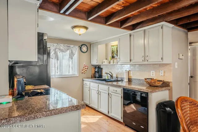 a kitchen with granite countertop a sink stove and cabinets