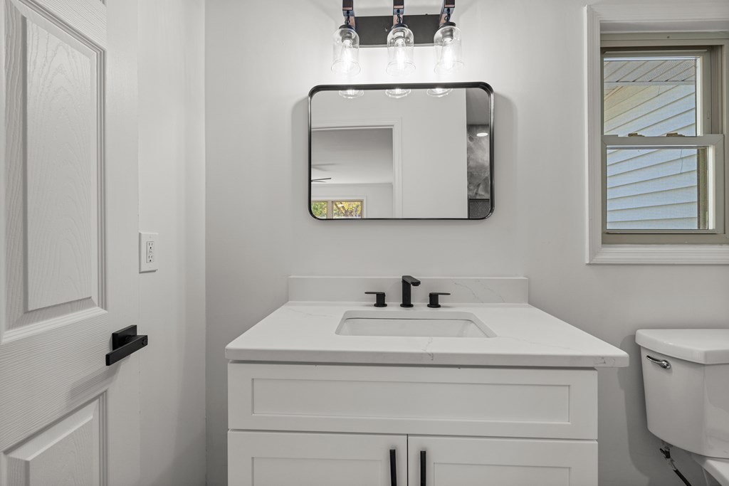4903 Chapman Street Columbus, GA 31907 - Photo 12 of 14 a bathroom with a toilet sink and mirror