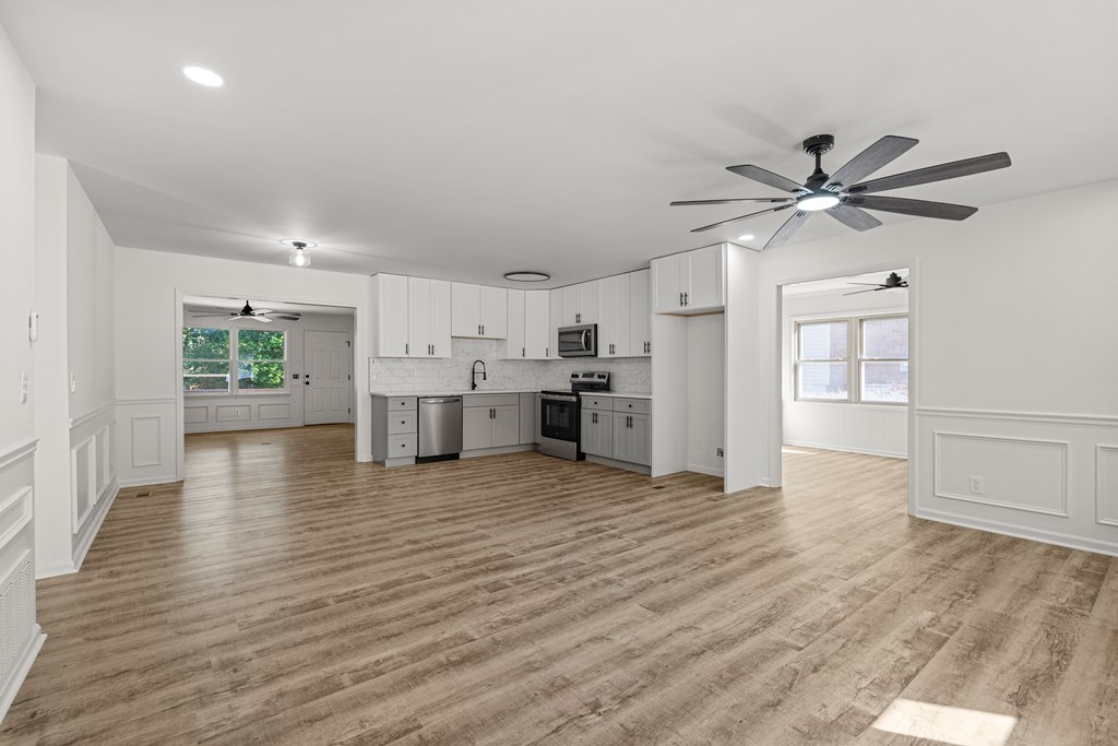 4903 Chapman Street Columbus, GA 31907 - Photo 2 of 14 a view of an empty room with a kitchen and wooden floor