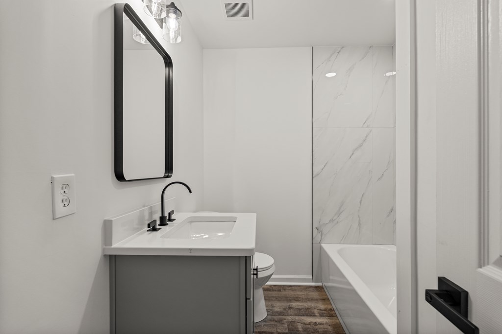 4903 Chapman Street Columbus, GA 31907 - Photo 10 of 14 a bathroom with a sink and mirror with bathtub