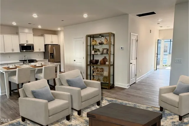 a living room with furniture kitchen view and a refrigerator