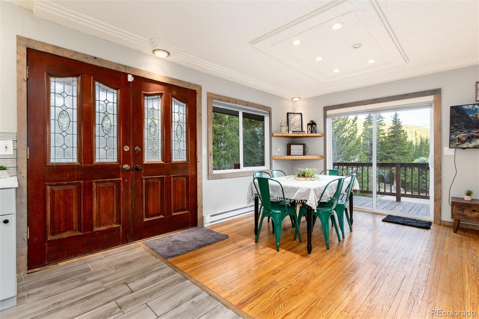 159 Lake Road Idaho Springs, CO 80452 - Photo 6 of 45 a dining room with wooden floor a chandelier a glass table and chairs
