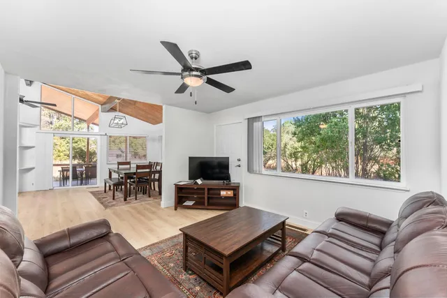 a living room with furniture a flat screen tv and a large window