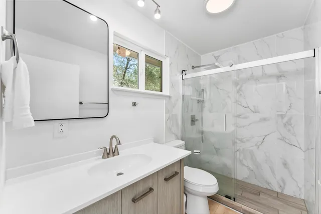 a bathroom with a sink a toilet and a mirror