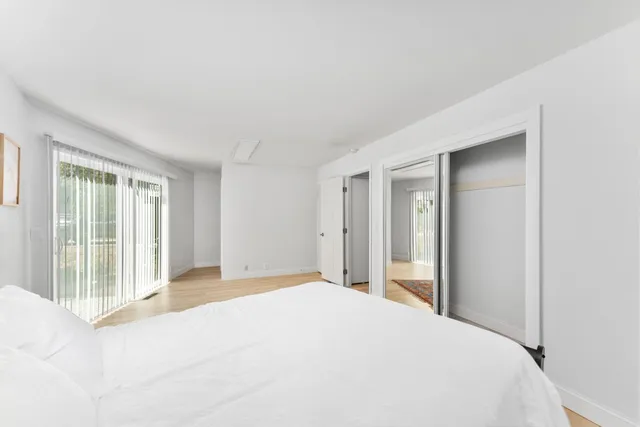 a bedroom with a bed and a large window