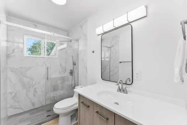 a bathroom with a sink toilet and shower