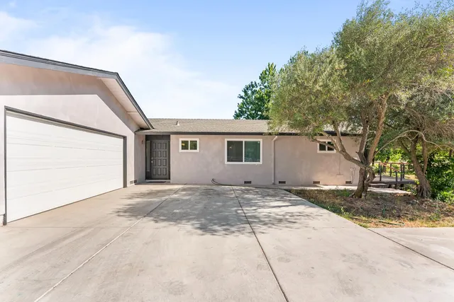a view of a house with a backyard and a tree