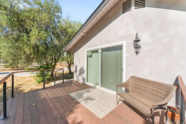 a backyard of a house with wooden floor and outdoor seating