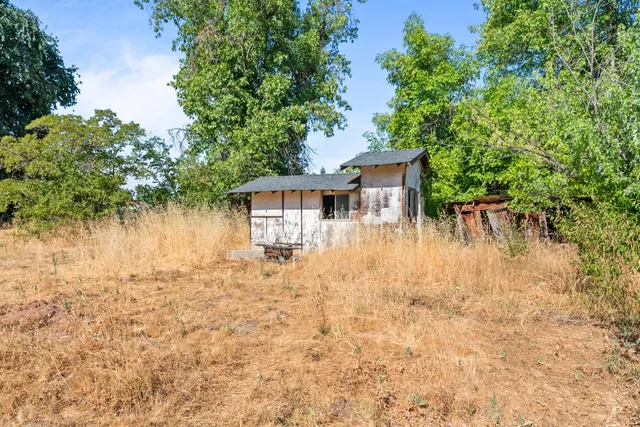 a front view of house with yard and trees around