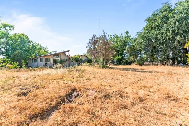 a backyard of a house with large trees