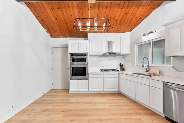 a kitchen with stainless steel appliances granite countertop a sink and cabinets