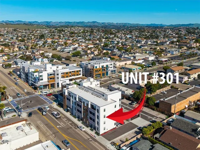 an aerial view of a city with lots of residential buildings and ocean view