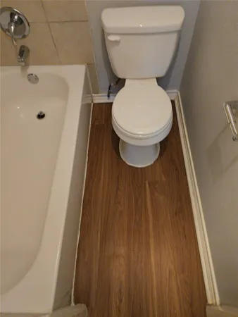 a view of empty room with wooden floor and fireplace
