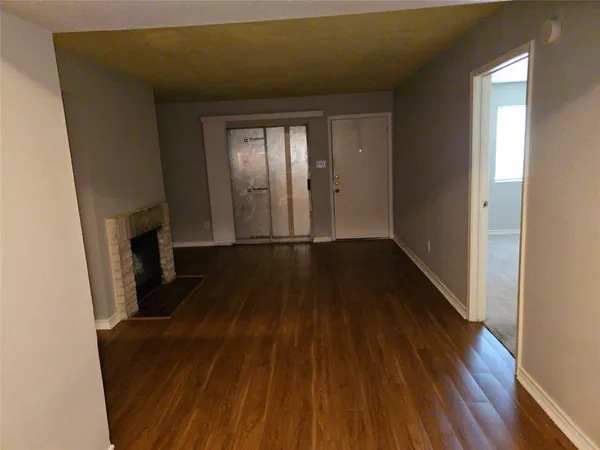 a view of a livingroom with wooden floor and staircase