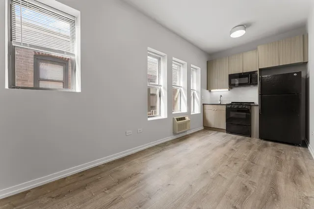 a kitchen with granite countertop a refrigerator and a stove top oven
