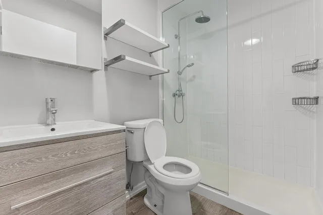 a bathroom with a sink a toilet and shower