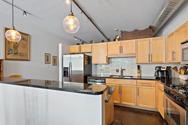 a kitchen with stainless steel appliances a sink a stove and cabinets