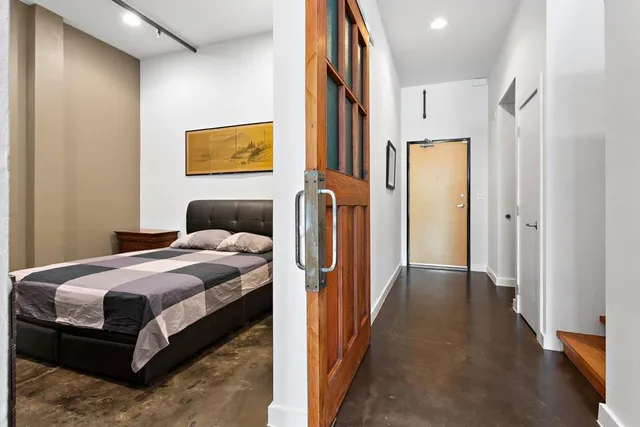 a bedroom with a bed and wooden floor