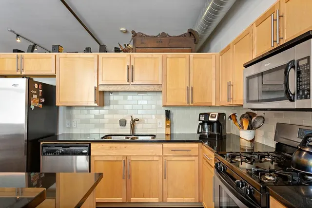 a kitchen with stainless steel appliances granite countertop a stove and a sink