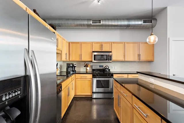 a kitchen with stainless steel appliances and a refrigerator