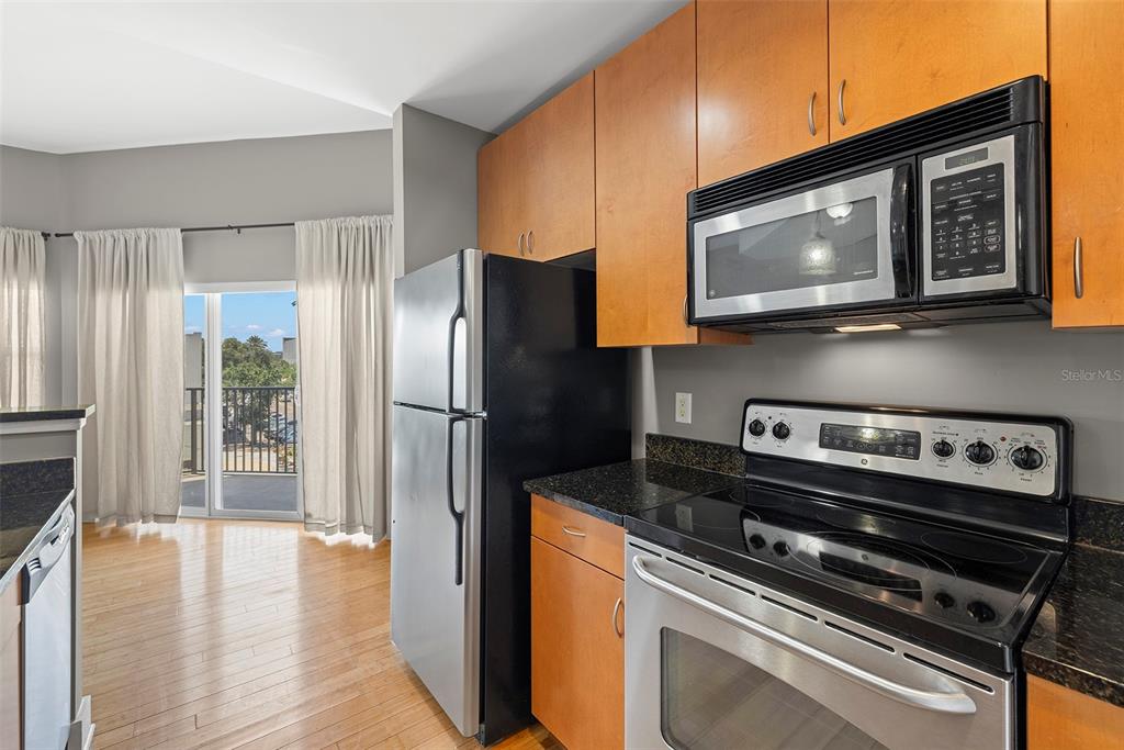 1010 Central Avenue, Unit 302 St. Petersburg, FL 33705 - Photo 12 of 50 a kitchen with stainless steel appliances granite countertop a refrigerator microwave and sink